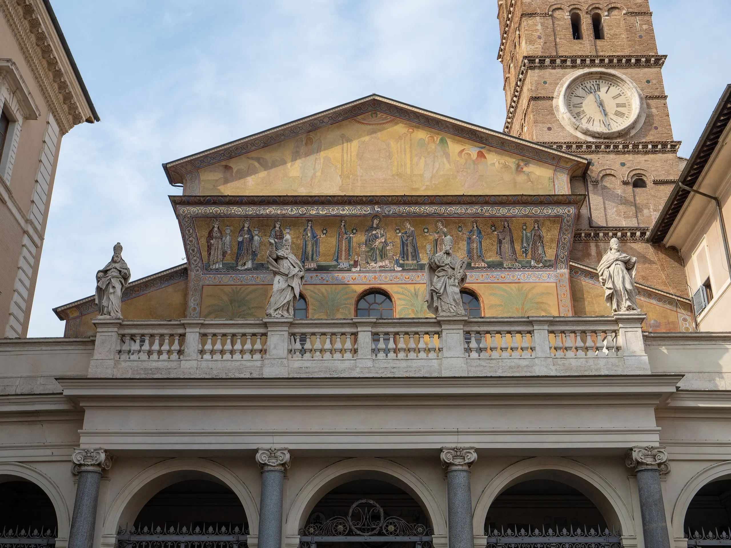 The facade of Santa Maria in Trastevere with its gold mosaic frieze and bell tower.
