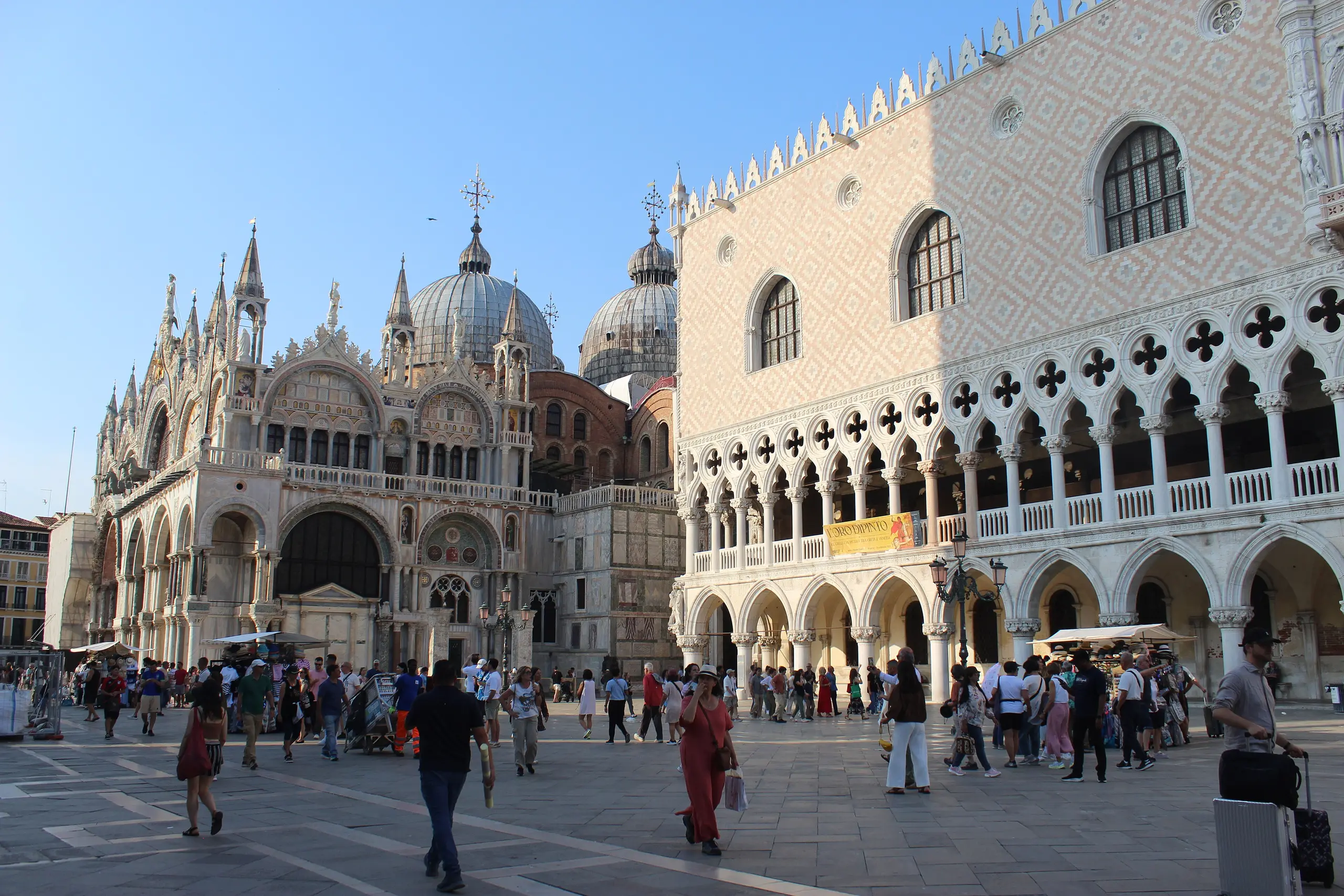 Piazza San Marco in Venice with the basilica's domes and the Doge's Palace in clear morning light.